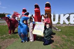 参加者を呼び掛ける、長岡代表（前列左）らとティラノサウルス