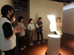 ワークショップに参加した高校生に作品づくりについて説明する加藤さん（右）