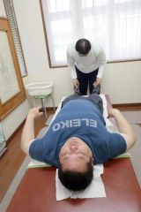 足首の違和感から及川のフォームの欠点を指摘する高橋真吾院長（奥）