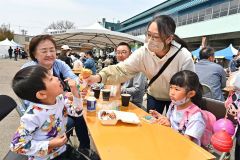 料理を頬張る子ども（４日午前１１時半ごろ、帯広競馬場で。金野和彦撮影）