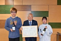 感謝状を受け取った橋本会長（中央）と川口男子寮寮長（左）、古賀女子寮副寮長