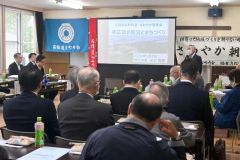 あいさつする加藤会長代行（右）