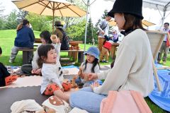 木のおもちゃで遊ぶ親子連れ