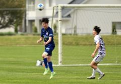 前半、ヘディングでクリアし相手の攻撃を阻む内山裕貴（青色のユニホーム、左）＝金野和彦撮影