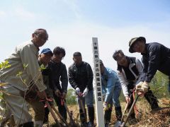 記念標柱を建立する中村会長（中央）ら