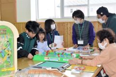 ボードゲームなどを楽しむ子どもたちとサロンメンバー（左から４人目が宮越代表）