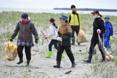 海岸のごみを拾い集める児童ら