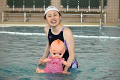 人形を手に親子連れに指導する山田さん