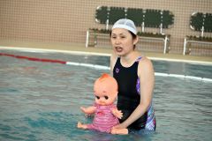 人形を手に親子連れに指導する山田さん