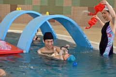 楽しくトンネルをくぐり、水を浴びる親子連れ