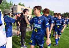 試合後、ファンとタッチを交わし、笑顔を見せるスカイアースの丸岡悟（手前）＝金野和彦撮影