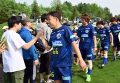 試合後、ファンとハイタッチを交わすスカイアースの選手たち。手前は丸岡悟選手（金野和彦撮影）