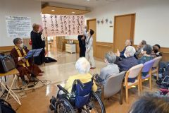 ウクレレの演奏に合わせて歌う入居者ら