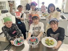 完成したお菓子を手に笑顔を見せる中高生