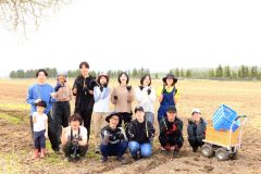 収穫したアスパラを手に笑顔の参加者