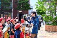 閉店となった藤丸の前で当時の様子を児童に解説する大和田学芸員（右）