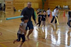 ウレタン棒を使った鬼ごっこを楽しむ園児