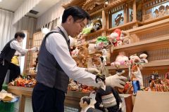 祭壇に人形などを並べる職員