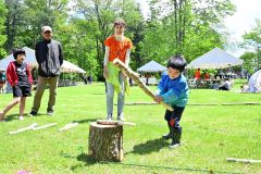 「棍棒飛ばし」を体験する参加者と安藤さん（中央）