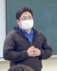 あいさつする新津委員長