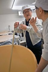 仕込み途中のタンクを確認し、若山さんと話しをする日吉さん