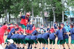 慎重に背中を渡る生徒（１日、帯広第五中学校。長尾悦郎通信員撮影）