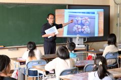 ニンニクについて説明する十勝清水農協の石井監査役と真剣に聞く児童ら（５月２８日午後１時２０分ごろ、花園小学校）