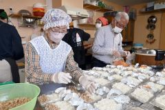 弁当の盛り付けを行う民生委員ら