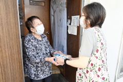 笑顔で弁当を受け取る高齢者
