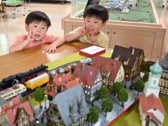 鉄道模型を前にポーズをとる子ども達
