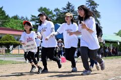 ＵＶ対策していますか？－。借り人競走のお題に合わせた観客と一緒にゴールを目指す児童（８日、鹿追上幌内小学校。須貝拓也撮影）