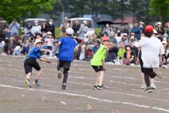 「次は俺に任せろ」－。５・６年生のリレーで、競り合う子どもたち（８日、更別小学校。金野和彦撮影）