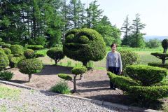 庭のオンコの木で人の顔や鳥を形作っている高橋さん