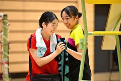 女子シングルス準決勝で勝利し、インターハイ出場を決めた旭川実の杉野冬花（２年、左、帯一中出）。試合後、対戦相手の中島優衣奈（旭川商３年、同）と笑顔で健闘をたたえ合う（金野和彦撮影）