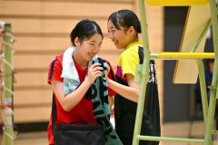 女子シングルス準決勝で勝利し、インターハイ出場を決めた旭川実の杉野冬花（２年、左、帯一中出）。試合後、対戦相手の中島優衣奈（旭川商３年、同）と笑顔で健闘をたたえ合う（金野和彦撮影）