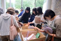 今年度初めて無料提供された雑誌の付録を品定めする来場者ら