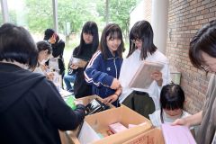 今年度初めて無料提供された雑誌の付録を品定めする来場者ら