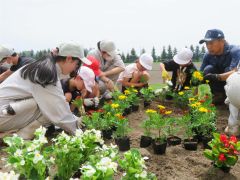 更農の生徒と花植に取り組む児童たち