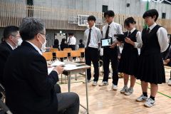 企業担当者へプレゼンテーションをする生徒