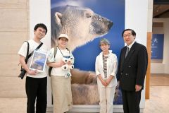 来館者１万５０００人目となった吉﨑大輔さん・圭さん夫妻（左）と星野道夫さんの姉・三原京子さん（右から２番目）、帯広美術館振興会の川田章博会長（右端）