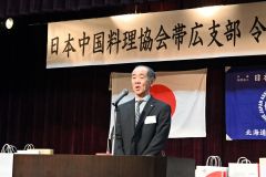 あいさつする漆原新支部長