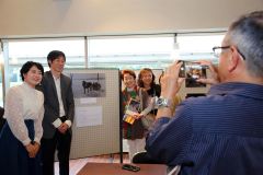 来場者と映画撮影のきっかけとなった荘田喜與志さん＝帯広＝の写真の前で記念撮影に応じる（左から）東盛さん、逢坂監督
