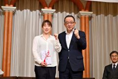 東野有紗選手（左）へ激励金を贈る南空知地区バドミントン協会の村木中会長（金野和彦撮影）