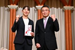 永原和可那選手（左）に激励金を贈る十勝地区バドミントン協会の林浩史会長（金野和彦撮影）