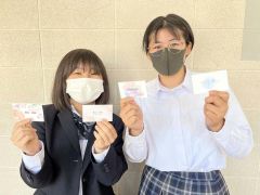 完成した名刺を手に笑顔を見せる生徒たち