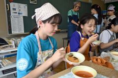 音更産のコロッケを食べる児童ら