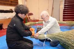 スゲを芯に結びつける池田正幸さん（右）と正樹さん（２６日午前９時２５分ごろ、帯廣神社、長尾悦郎通信員撮影）