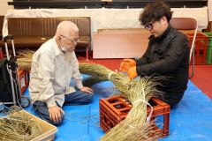 スゲを芯に結びつける池田正樹さん（右）と見守る正幸さん（２６日午前９時４０分ごろ、帯廣神社、長尾悦郎通信員撮影）