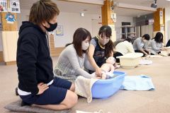 保健師から沐浴について学ぶ母親（左から２人目）