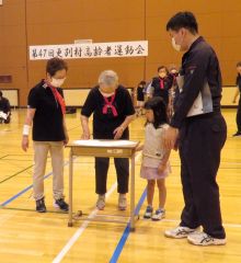 動物のお面を園児と一緒に探すお年寄り